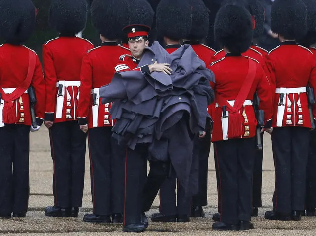 Guardsmen of the Grenadier Guards remove their capes during the Colonel's Review ceremony at Horse Guards Parade in London. (Photo by Luke MacGregor/Reuters)
