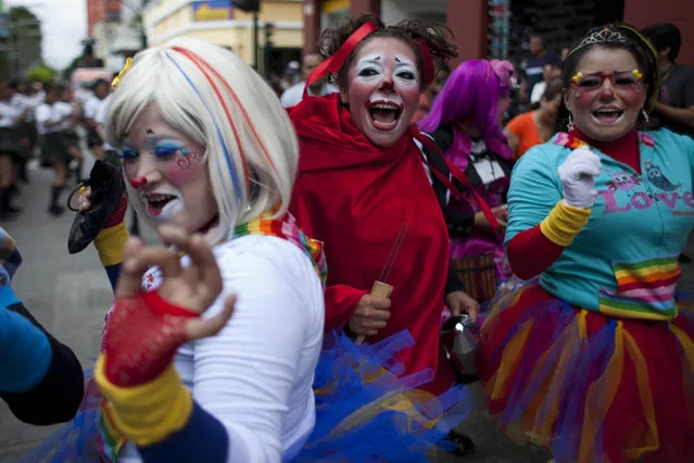 Clowns dance in the Parade of Clowns as part of the sixth annual Latin American Clown Congress in Guatemala City, Tuesday, July 29, 2014. Clowns from Central America and North America have gathered for four days in the capital city to exchange ideas and attend workshops. (Photo by Moises Castillo/AP Photo)
