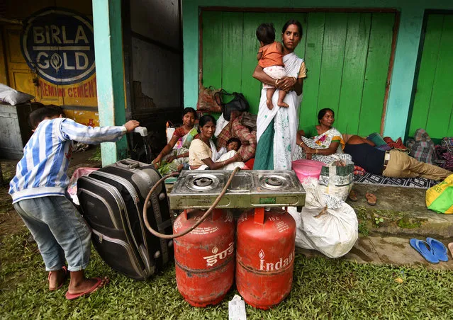 Flood affected families take shelter in front of a shop and wait for relief material in Jakhalabandha area in Nagaon district, in the northeastern state of Assam, India, August 13, 2017. (Photo by Anuwar Hazarika/Reuters)