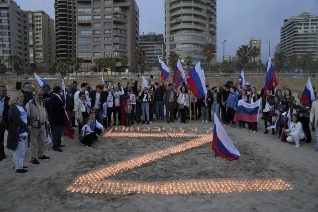 People gather near lit candles during an event organized by a group of Russia supporters to show solidarity with Moscow against Ukraine in Beirut, Lebanon, Saturday, April 9, 2022. (Photo by Hassan Ammar/AP Photo)
