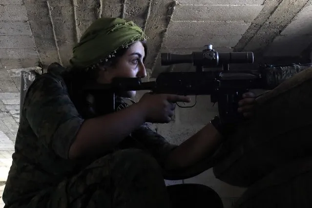 A female member of the Syrian Democratic Forces (SDF), a US backed Kurdish-Arab alliance, holds a position inside a building in an area close to the Old City in the embattled northern Syrian city of Raqa on September 3, 2017, as they battle to retake the city from the Islamic State (IS) group. (Photo by Delil Souleiman/AFP Photo)