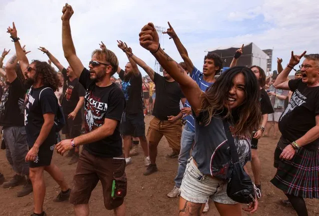 Festivalgoers cheer during the Wacken Open Air 2022 heavy metal festival in Wacken, Germany on August 4, 2022. (Photo by Thilo Schmuelgen/Reuters)
