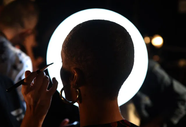 A model gets her make up on backstage before the Coach fashion show at Pier 36 during New York Fashion Week on September 12, 2017, in New York. (Photo by Timothy A. Clary/AFP Photo)