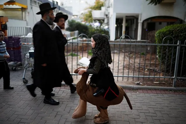 A girl wears a costume as she walks during the Jewish holiday of Purim, a celebration of the Jews' salvation from genocide in ancient Persia, as recounted in the Book of Esther, in Ashdod, Israel on March 9, 2020. (Photo by Amir Cohen/Reuters)