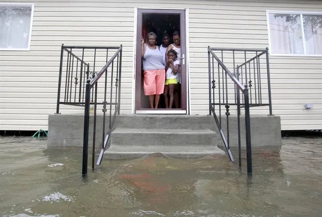 Lessie Lewis, Devin Lewis, Kodi Lewis and Cindy Lewis stand on the front porch as floodwaters surround their home on St. Roch Avenue in New Orleans, La., on Aug. 29. (Photo by Sean Gardner/Reuters)