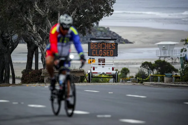 A cyclist rides past a closed beach sign during the outbreak of the coronavirus disease (COVID-19) in Del Mar, California, U.S. April 30, 2020. (Photo by Mike Blake/Reuters)