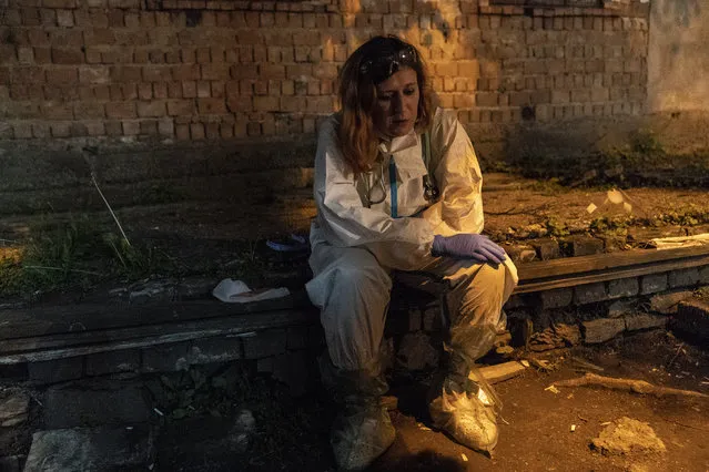 In this photo taken on Saturday, May 9, 2020, Dr. Dr Olha Kobevko takes a quick break outside the regional hospital in Chernivtsi, Ukraine. The hospital lacks a centralized oxygen supply and has to rely mostly on refillable oxygen masks, reflecting a pitiful state of Ukraine's underfunded health care system that was quickly overwhelmed by the coronavirus even with a relatively low number of infections. (Photo by Evgeniy Maloletka/AP Photo)