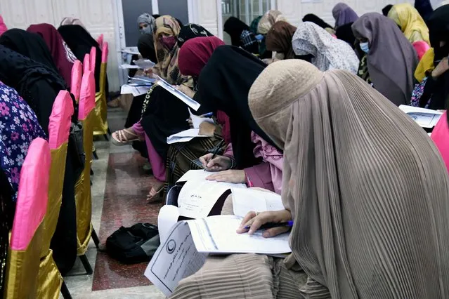 Afghan burqa-clad women take an entrance test at Mamon Tahiri institute in Kandahar on September 15, 2022. (Photo by Javed Tanveer/AFP Photo)