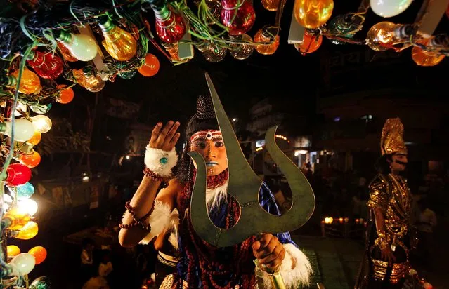 An artist dressed as a Hindu God participates in a Dussehra procession in the northern Indian city of Allahabad, on October 11, 2012.  The procession was part of Hindu festival Dussehra celebrations, commemorating the triumph of Lord Rama over the demon king Ravana, marking the victory of good over evil. (Photo by Rajesh Kumar Singh/Associated Press)