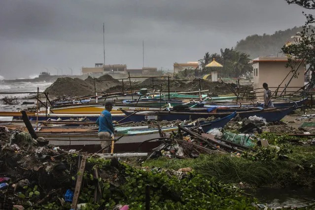 Residents stand next to docked fishing boats as Typhoon Vongfong hits on May 15, 2020 in Atimonan town, Quezon province, Philippines. Thousands of residents fled to evacuation centers on Friday as Typhoon Vongfong slammed the Philippines' main island of Luzon, dumping torrential rains and raising fears that the coronavirus could spread in packed evacuation centers. (Photo by Ezra Acayan/Getty Images)