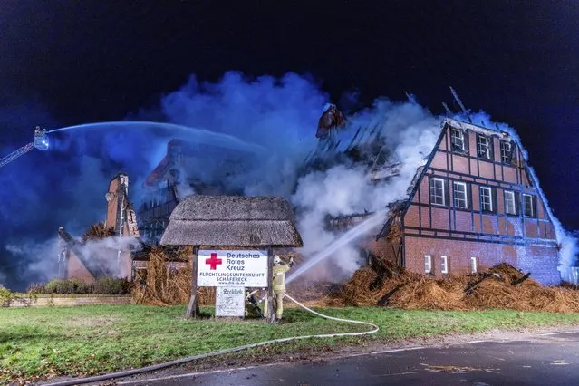 Firefighters extinguish the fire in a hotel where refugees from Ukraine were accommodated in Gross Stroemkendorf, Germany, Thursday, October 20, 2022. A fire has almost completely destroyed a shelter for refugees from Ukraine in the municipality of Groß Strömkendorf in Mecklenburg-Western Pomerania on Thursday night. (Photo by Jens Büttner/dpa/via AP Photo)
