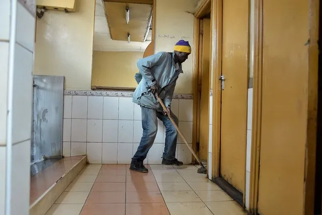 A man cleans public toilets on November 7, 2017 in the Kawangware district of Nairobi, Kenya. (Photo by Simon Maina/AFP Photo)