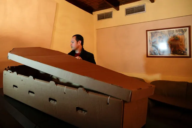 Alejandro Blanchard assembles a cardboard coffin at a mortuary in Valencia, in the state of Carabobo, Venezuela August 25, 2016. (Photo by Marco Bello/Reuters)