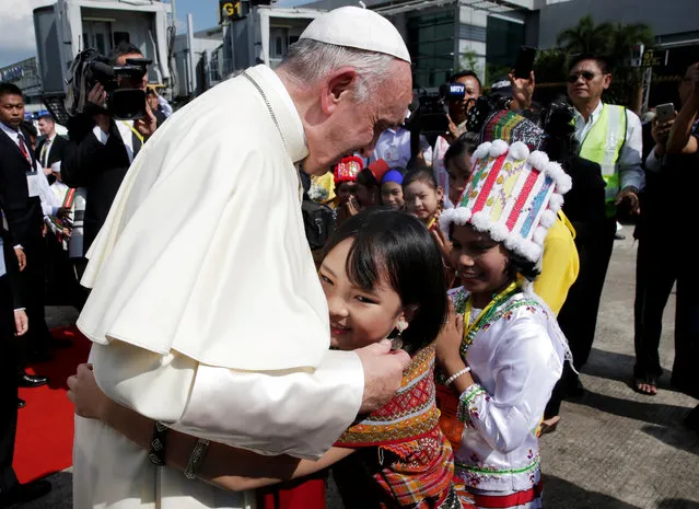 A girl embraces Pope Francis as he arrives at Yangon International Airport, Myanmar on November 27, 2017. (Photo by Max Rossi/Reuters)