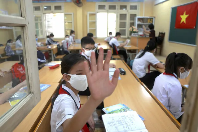 A student waves to her friends in Dinh Cong secondary school in Hanoi, Vietnam Monday, May 4, 2020. Students across Vietnam return to school after three months of studying online due to school closure to contain the spread of COVID-19. (Photo by Hau Dinh/AP Photo)