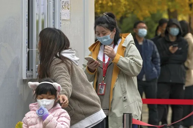 Residents line up to get their routine COVID-19 throat swabs at a coronavirus testing site in Beijing, Tuesday, November 8, 2022. (Photo by Andy Wong/AP Photo)