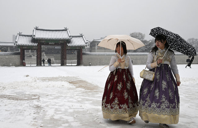 Visitors wearing traditional hanbok dresses walk on the snow-covered grounds of Gyeongbokgung Palace during snowfall in central Seoul on February 12, 2025. (Photo by Jung Yeon-je/AFP Photo)