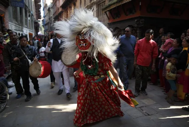 A masked dancer performs to drumbeat during the Newari New Year parade that falls during the Tihar festival, also called Diwali, in Kathmandu October 24, 2014. (Photo by Navesh Chitrakar/Reuters)