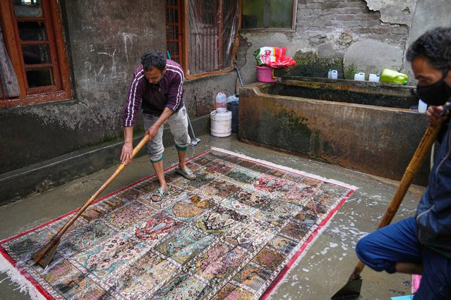 Professional carpet cleaners Waseem Ahmed Mir, left, and Abid Ahmed wash Kashmiri hand-knotted carpets at a workshop in Srinagar, Indian controlled Kashmir, on April 12, 2025. (Photo by Dar Yasin/AP Photo)
