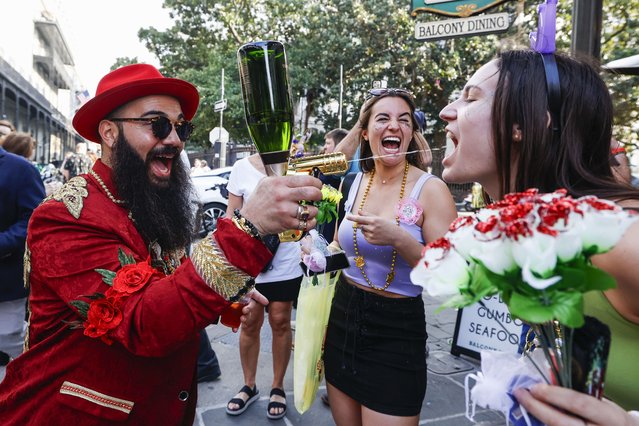 A person sprays champagne into the mouth of another Mardi Gras reveler in the French Quarter in New Orleans, Friday, February 9, 2024. (Photo by Sophia Germer/The Times-Picayune/The New Orleans Advocate via AP Photo)