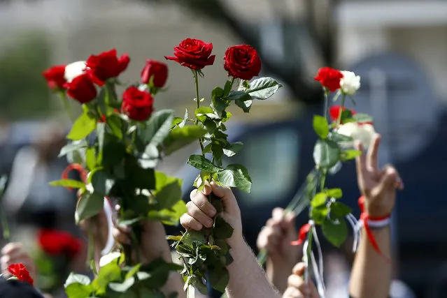 People wave flowers at the farewell hall during the funeral of Alexander Taraikovsky who died amid clashes protesting the election results, in Minsk, Belarus, Saturday, August 15, 2020. Taraikovsky died Monday as demonstrators roiled the streets of the capital Minsk, denouncing official figures showing that authoritarian President Alexander Lukashenko, in power since 1994, had won a sixth term in office. (Photo by Sergei Grits/AP Photo)