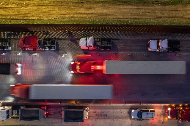 Aerial view of cargo trucks heading towards US at the Otay Commercial crossing in Tijuana, Baja California state, Mexico on March 27, 2025. Mexico said on March 27, 2025, that it wanted preferential treatment if US President Donald Trump goes ahead with steep car tariffs, vowing a “comprehensive response” to Washington's duties. (Photo by Guillermo Arias/AFP Photo)