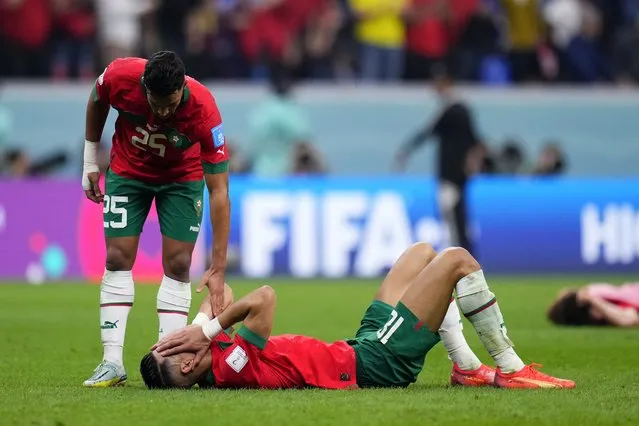 Morocco's Yahia Attiyat Allah consoles a teammate at the end of the World Cup semifinal soccer match between France and Morocco at the Al Bayt Stadium in Al Khor, Qatar, Wednesday, December 14, 2022. France won 2-0 and will play Argentina in Sunday's final. (Photo by Manu Fernandez/AP Photo)