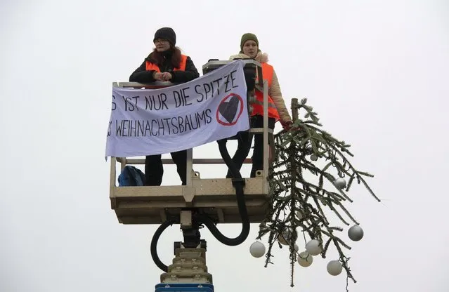 Two activists of the environmental group drove a lift truck in front of the Christmas tree on Pariser Platz at the Brandenburg Gate in Berlin on December 21, 2022. They unfurled a banner and then removed the top of the Christmas tree – “It's just the top of the Christmas tree” is written on the banner of the activists of the “Last Generation”. (Photo by Paul Zinken/dpa)