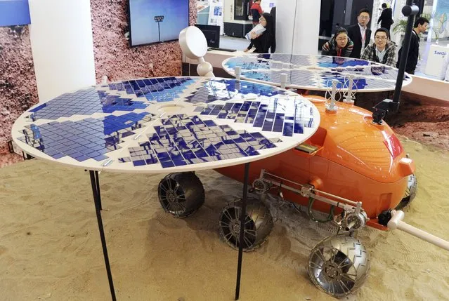 Visitors look at a prototype model of a Mars rover, which was designed and built in China, on display at the China International Industry Fair in Shanghai, November 4, 2014. (Photo by Reuters/Stringer)