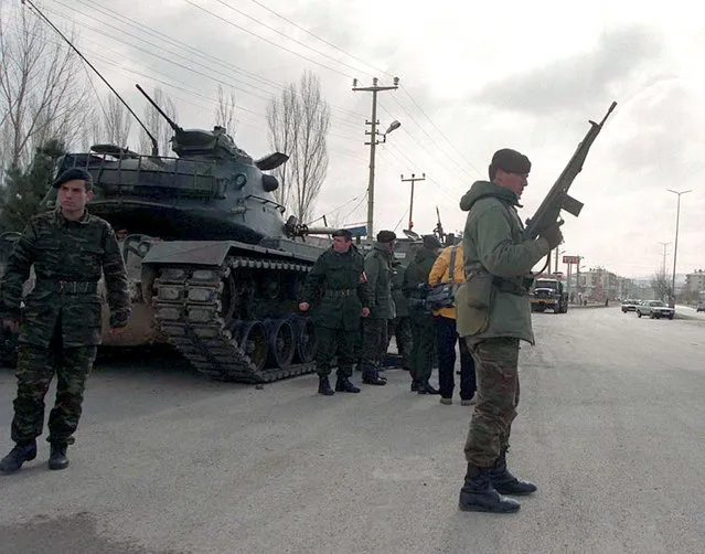A Turkish soldier stands guard near tanks and armoured vehicles paraded through the main street of Sincan, a district near capital Ankara, Turkey, in this file photo taken on February 4, 1997. (Photo by Reuters/File photo)