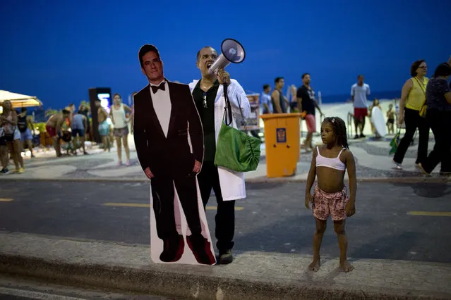 A demonstrator holds a card board cutout of Sergio Moro, the Brazilian federal judge responsible for the “Operation Car Wash” corruption investigation, during a protest against former President Luiz Inacio Lula da Silva on Copacabana beach, in Rio de Janeiro, Brazil, Tuesday, January 23, 2018. Brazil's political future could be decided this week when a court decides whether a rooftop apartment was slated for former President Luiz Inacio Lula da Silva, the front runner in polls for October's elections. (Photo by Silvia Izquierdo/AP Photo)