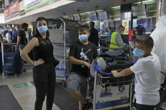 Passengers from Middle East Airline wearing face masks to protect against coronavirus wait to check in at the departure hall of the Murtala Muhammed International Airport in Lagos Nigeria Saturday, September 5, 2020. Nigeria officials resumed International flights Saturday following months of closure to curb the spread of coronavirus. (Photo by Sunday Alamba/AP Photo)