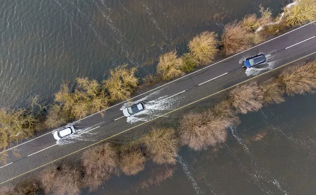 Cars make their way along the flooded A1101 in Welney in Norfolk, United Kingdom where the River Delph and New Bedford River have flooded the surrounding area on Thursday, January 5, 2023. (Photo by Joe Giddens/PA Wire)