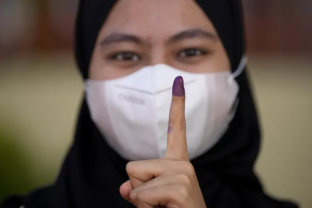 A woman shows her inked finger after voting in Seberang Perai, Penang state, Malaysia, Saturday, November 19, 2022. Malaysians began casting ballots Saturday in a tightly contested national election that will determine whether the country's longest-ruling coalition can make a comeback after its electoral defeat four years ago. (Photo by Vincent Thian/AP Photo)