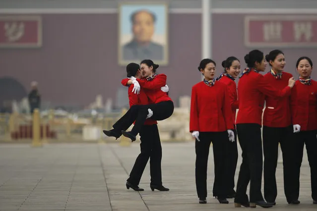 Hospitality staff members have fun as they take souvenir pictures on Tiananmen Square during a plenary session of Chinese People's Political Consultative Conference (CPPCC) at the Great Hall of the People in Beijing, Wednesday, March 14, 2018. (Photo by Andy Wong/AP Photo)