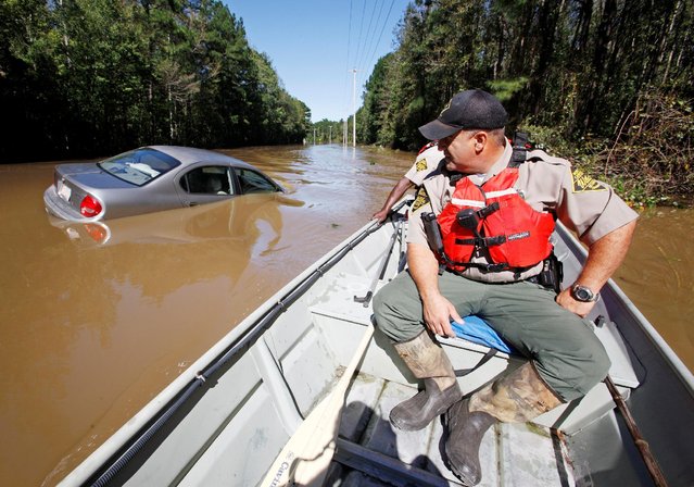 North Carolina Wildlife Resources Commission officers search by boat over a submerged road for those in need of rescue as river waters rise dangerously after Hurricane Matthew hit the state, in Lumberton, North Carolina October 10, 2016. (Photo by Jonathan Drake/Reuters)