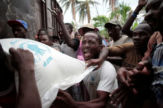 Residents try to get a sack of rice, after a distribution was rescheduled and food was to be stored, following Hurricane Matthew in Saint Jean du Sud, Haiti, October 16, 2016. (Photo by Andres Martinez Casares/Reuters)