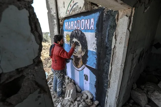 A graffiti artist Syrian Aziz Esmer draws a portrait of Diego Armando Maradona on the walls of a home destroyed after the attacks of Assad regime forces, in Idlib, Syria on November 27, 2020. (Photo by zzeddin idilbi/Anadolu Agency via Getty Images)