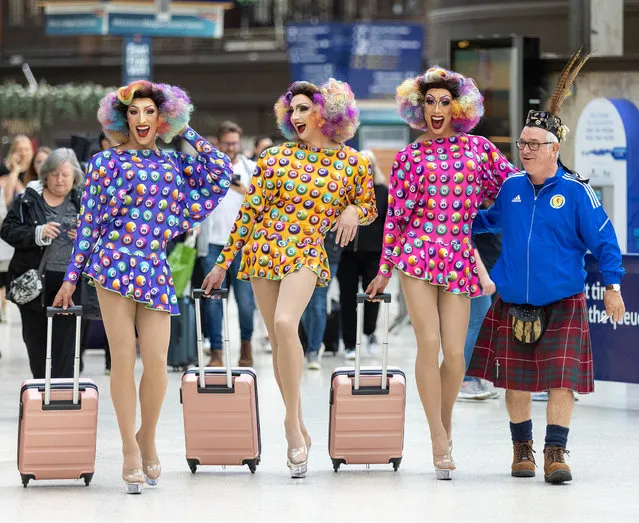 The drag troupe Dabber Dolls, arriving in Glasgow Central station on September 21, 2022 for their first tour of Mecca Bingo halls, are joined by a Scottish fan. (Photo by Robert Perry/The Guardian)