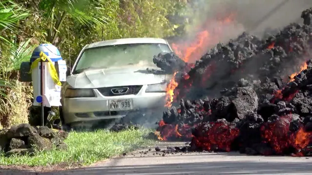 Lava engulfs a Ford Mustang in Puna, Hawaii, U.S., May 6, 2018 in this still image obtained from social media video. (Photo by WXCHASING via Reuters)