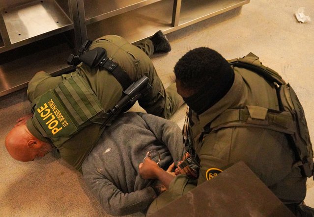 A person is detained by US Border Patrol agents inside a fast-food restaurant under construction in Charlotte, North Carolina, on Wednesday, November 19, 2025. More than 250 arrests were made across the city during a dayslong immigration enforcement operation. (Photo by Ryan Murphy/Getty Images)