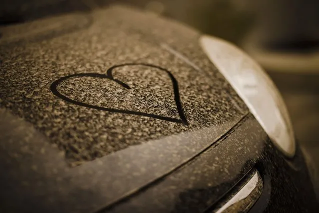 A drawn heart is seen on a black painted car covered with sahara dust, in Zurich, Switzerland on March 15, 2022. A huge dust storm is swirling over Europe from the Sahara desert. (Photo by Michael Buholzer/Keystone via AP Photo)
