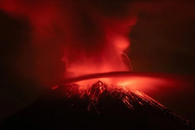 Incandescent materials, ash and smoke are spewed from the Popocatepetl volcano as seen from the San Nicolas de los Ranchos community, state of Puebla, Mexico, on May 23, 2023. Mexican authorities on May 21 raised the warning level for the Popocatepetl volcano to one step below red alert, as smoke, ash and molten rock spewed into the sky posing risks to aviation and far-flung communities below. Sunday's increased alert level – to “yellow phase three” – comes a day after two Mexico City airports temporarily halted operations due to falling ash. (Photo by Armando Vega/Reuters)