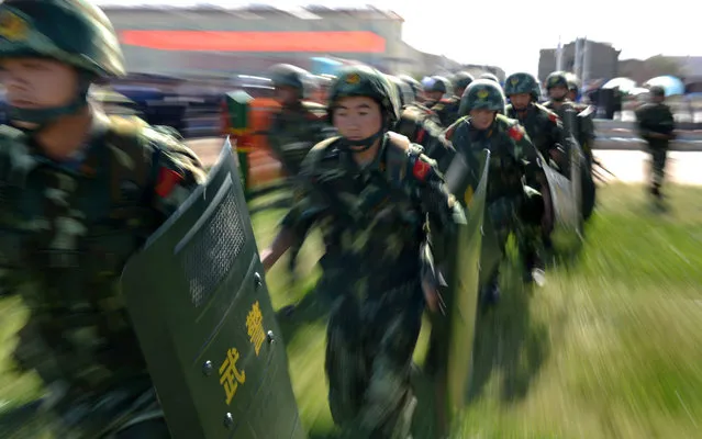 An anti-terrorism force including public security police and the armed police attend an anti-terrorism joint exercise in Hami, northwest China's Xinjiang region on July 2, 2013. The United States is encouraging “terrorism” in Xinjiang, Chinese state media said on July 1, also claiming that separatists in the region – which has a large Uighur minority – had fought alongside Syrian rebels. (Photo by AFP Photo)