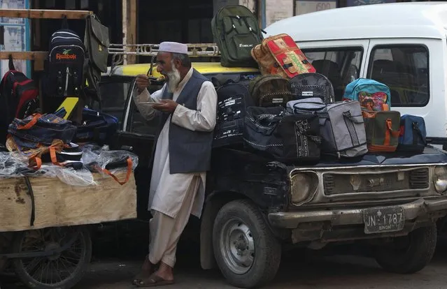 A man eats his lunch of boiled rice while selling bags along a road in Karachi January 21, 2015. (Photo by Akhtar Soomro/Reuters)