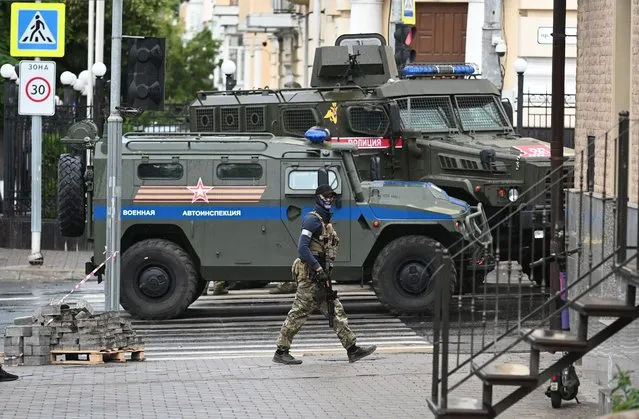 A fighter of Wagner private mercenary group patrols a street near the headquarters of the Southern Military District in the city of Rostov-on-Don, Russia on June 24, 2023. (Photo by Reuters/Stringer)