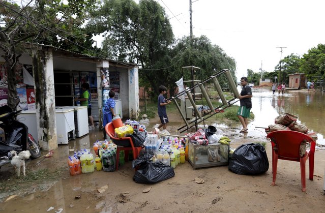Paraguayans remove their belongings from their flooded houses near the Paraguay river in Asuncion, December 20, 2015. (Photo by Jorge Adorno/Reuters)