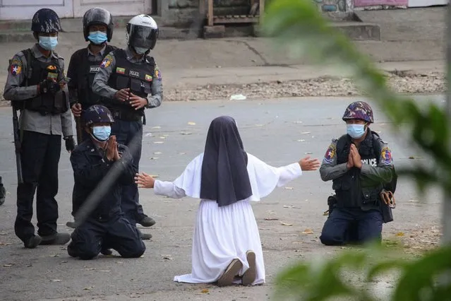 This handout photo taken on March 8, 2021 and released on March 9 by the Myitkyina News Journal shows a nun pleading with police not to harm protesters in Myitkyina in Myanmar's Kachin state, amid a crackdown on demonstrations against the military coup. (Photo by Myitkyina News Journal/Handout via AFP Photo)