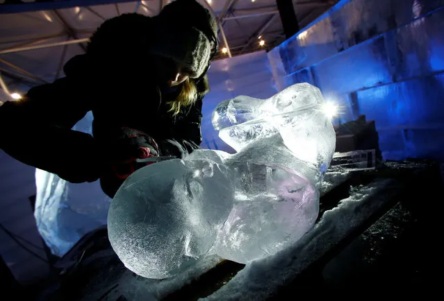 A sculptor carves a sculpture depicting the Christ child at the Snow and Ice Sculpture Festival “Eiswelt Mainz” in Mainz, Germany, November 22, 2016. (Photo by Ralph Orlowski/Reuters)