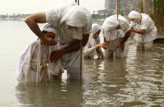 Followers of the Sabean Mandaeans, a pre-Christian sect that follows the teachings of John the Baptist, perform their rituals in the Tigris river during a celebration marking “Banja” or Creation Feast in central Baghdad, Iraq, Monday, March 15, 2021. Iraqi Sabaean Mandeans view the Bible's John the Baptist as savior and submerge themselves in the Tigris in an annual five-day ritual. (Photo by Hadi Mizban/AP Photo)